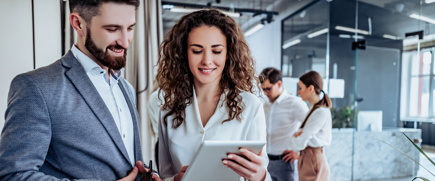 Ejecutivos revisando una tablet en una oficina corporativa moderna